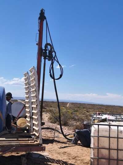 Maquinaria pesada realizando perforación profunda de agua en zona desértica industrial de Neuquén.